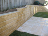 Retaining walls are an integral part of many landscape projects. Living Edge Landscapes offer walls finished in a variety of materials. Stone creates a solid look, sandstone or bushrock are often chosen. A brick retaining wall can be face brick or have a rendered finish. Retaining walls can also be made of concrete blocks or interlocking blocks. Treated pine is another option for your retaining wall, the main types are post and rail, dead men walls and crib types. Concrete, steel and footings are engineered into your retaining walls as required.